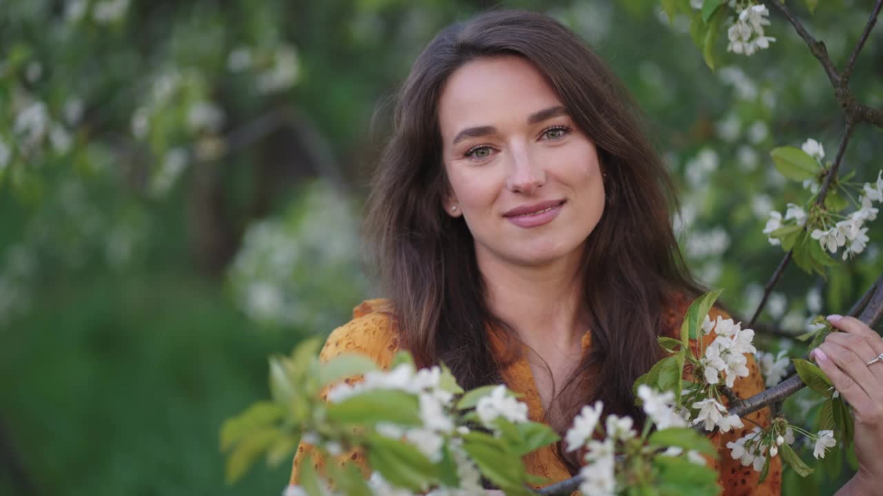 盛开的花园里的温柔天真的女人，春天果园里的漂亮淑女视频素材