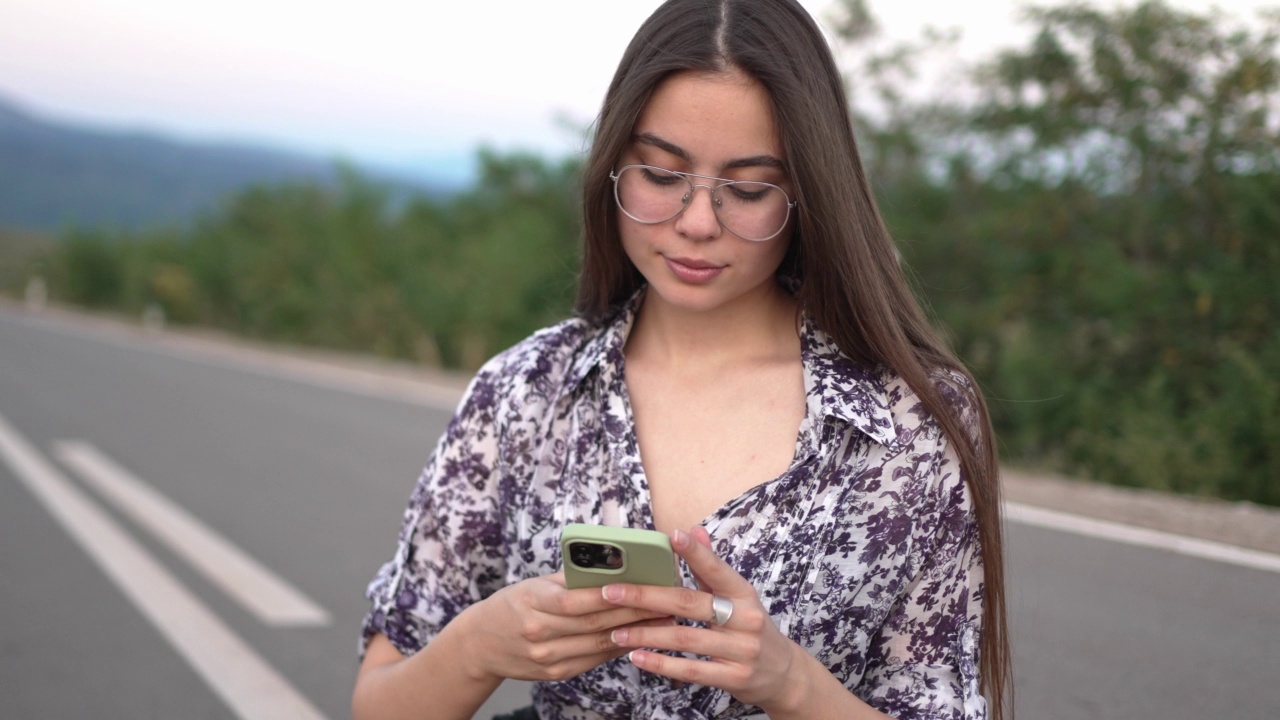 年轻的白人妇女站在高速公路上使用手机视频素材