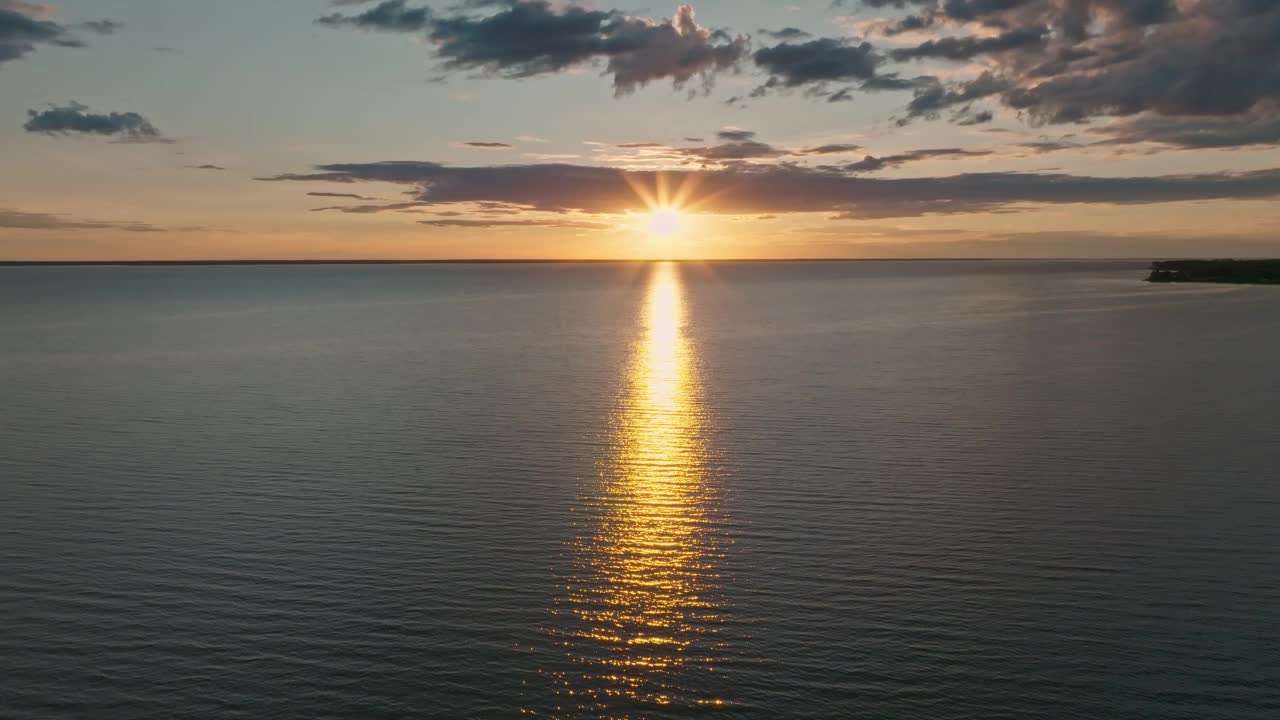 热带金色日落在海洋水的慢动作鸟瞰图。海景上的夕阳倒影。海湾无人沙滩。阳光明媚的傍晚，平静的水景。暑假。视频下载