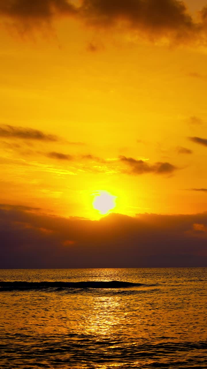 金色的海洋海滩日出。燃烧的太阳在天空上平静的海浪，4k垂直视频视频素材