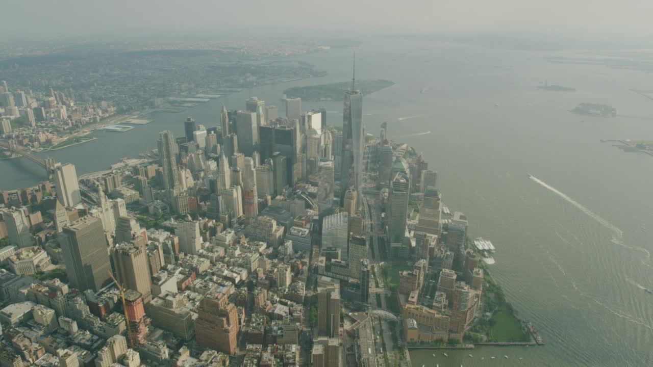 空中逆时针旋转的曼哈顿和纽约市天际线包括一个世界贸易中心或自由塔，布鲁克林桥，曼哈顿桥，总督岛。高楼大厦、摩天大楼和写字楼随处可见。纽约港，哈德森视频素材