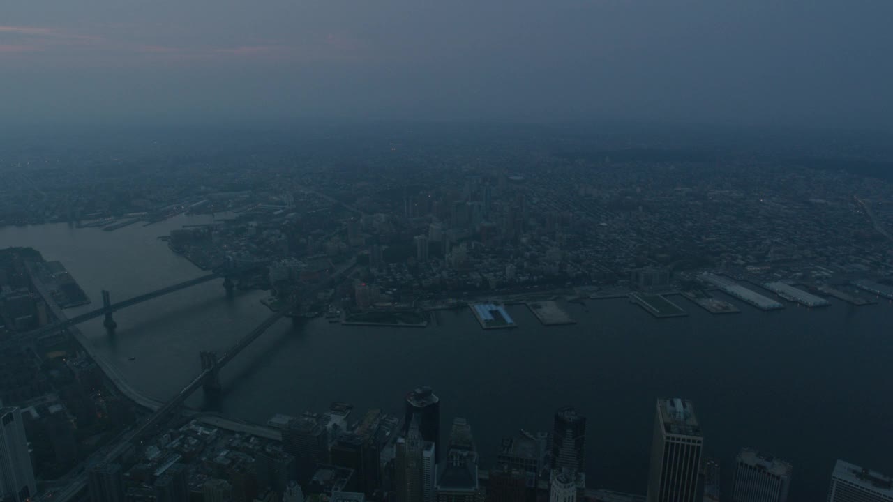 空中的东河和纽约市的天际线与曼哈顿和布鲁克林大桥可见。布鲁克林的天际线清晰可见。高楼大厦、办公大楼和摩天大楼随处可见视频素材