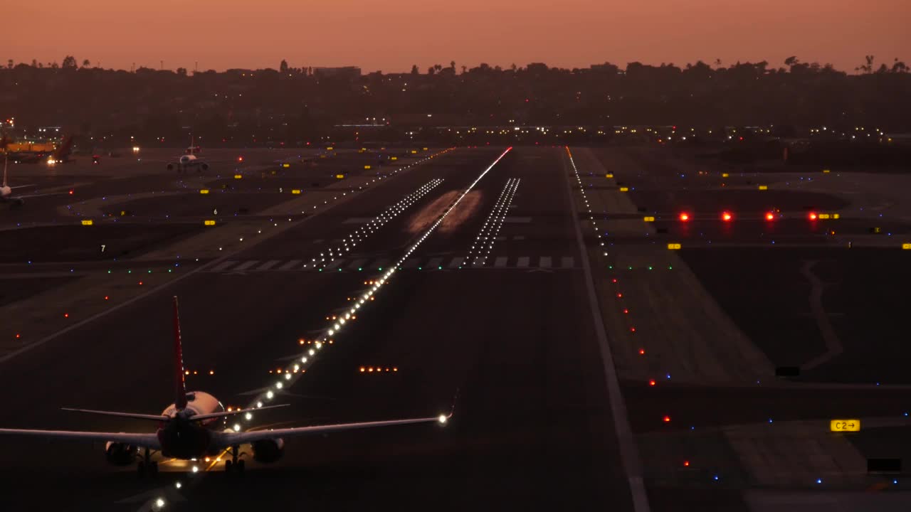 机场跑道灯光在晚上，飞机或航空公司起飞，机场跑道在日落。视频素材