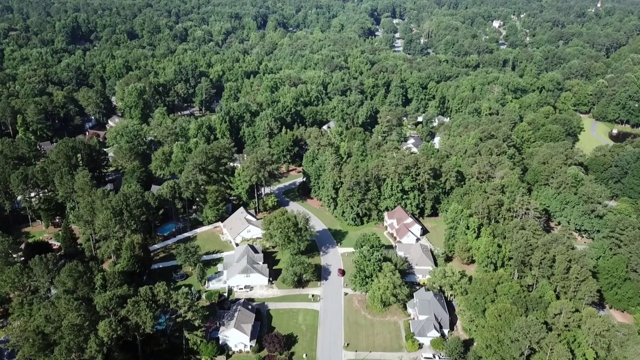 在树木和上层或中产阶级住宅区上空进行空中扫描。大房子可见。游泳池可见。可能是郊区。树木清晰可见。可能是佐治亚州的亚特兰大，也可能是伊利诺伊州的香槟市视频素材