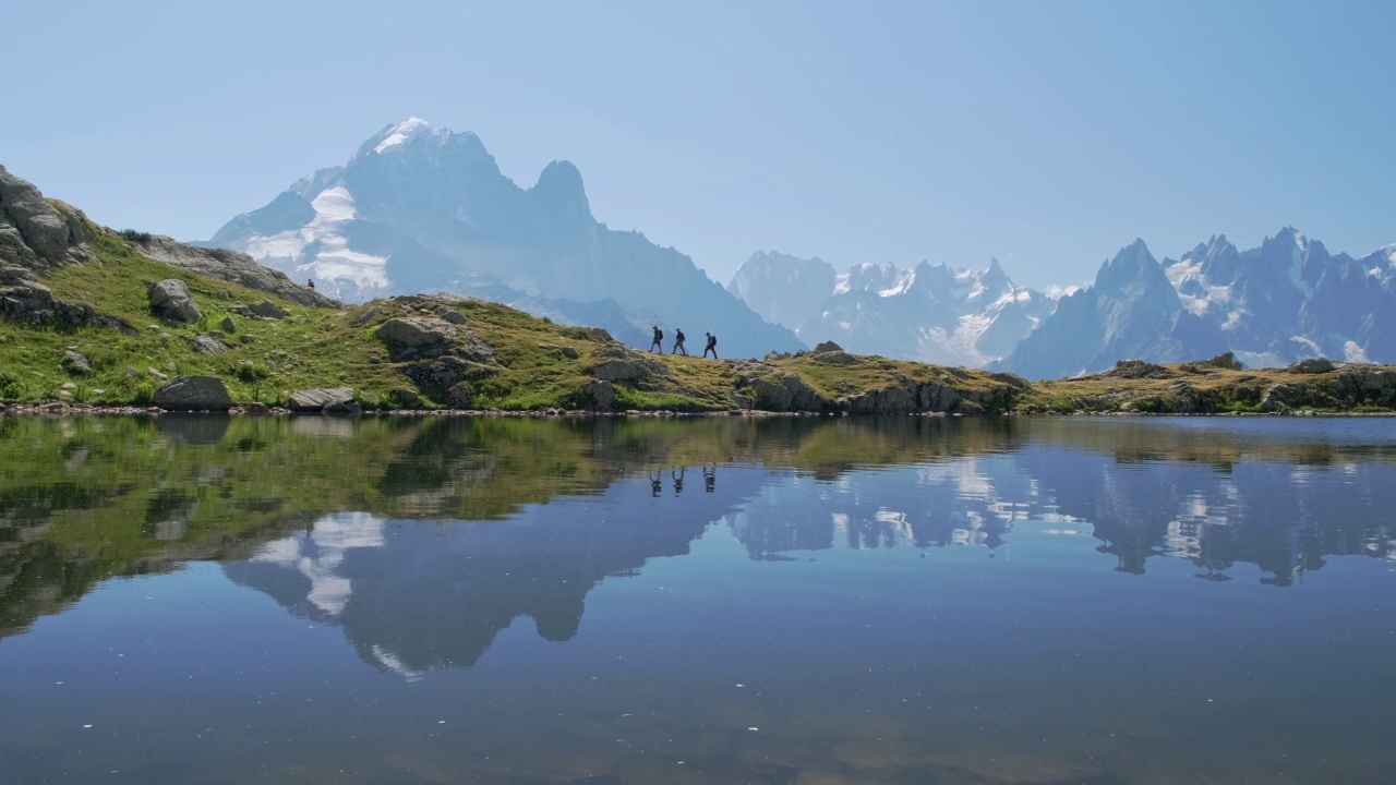 在霞慕尼山谷中，人们在山峰的倒影下徒步旅行。视频素材