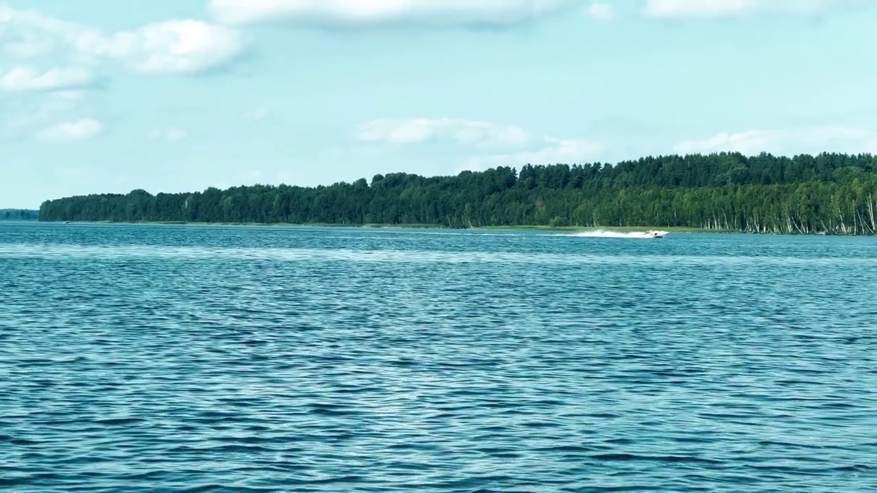 移动的渔船在海面上溅起水花。海洋海水反射波。湖中有摩托艇视频素材