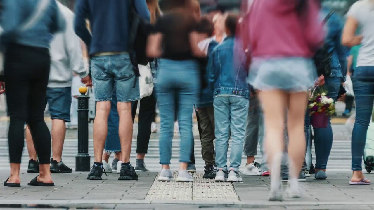 时间流逝，面目全非的人群穿过城市街道，繁忙的十字路口，行人穿过人行横道，汽车交通。时间流逝高峰时刻拥挤的人们行走，白昼，快速运动视频素材