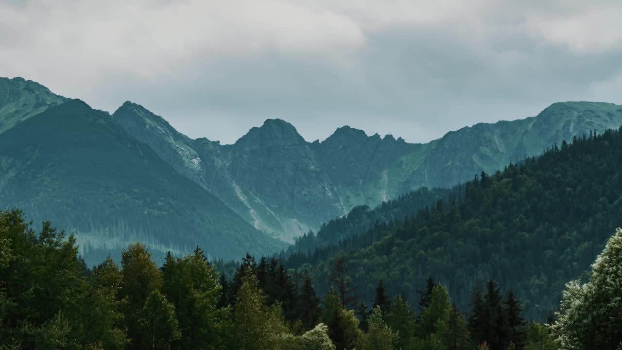 延时山脉覆盖着连绵的雨云。波兰塔特拉山脉的山峰。多云的夏日。史诗般的岩石高地和山丘上覆盖着翠绿的松树林视频素材