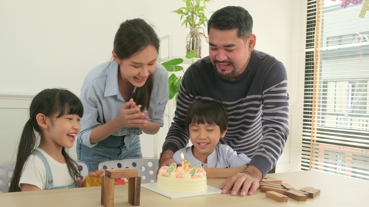 年幼的孩子们会为生日派对感到惊喜，并和家人一起庆祝。视频素材