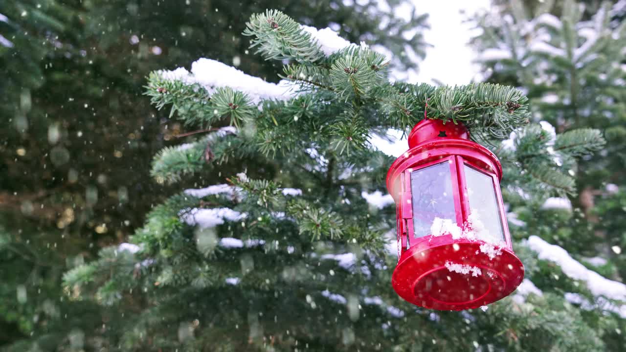 在圣诞节用红色灯笼点燃蜡烛，雪花飘落的电影摄影视频素材