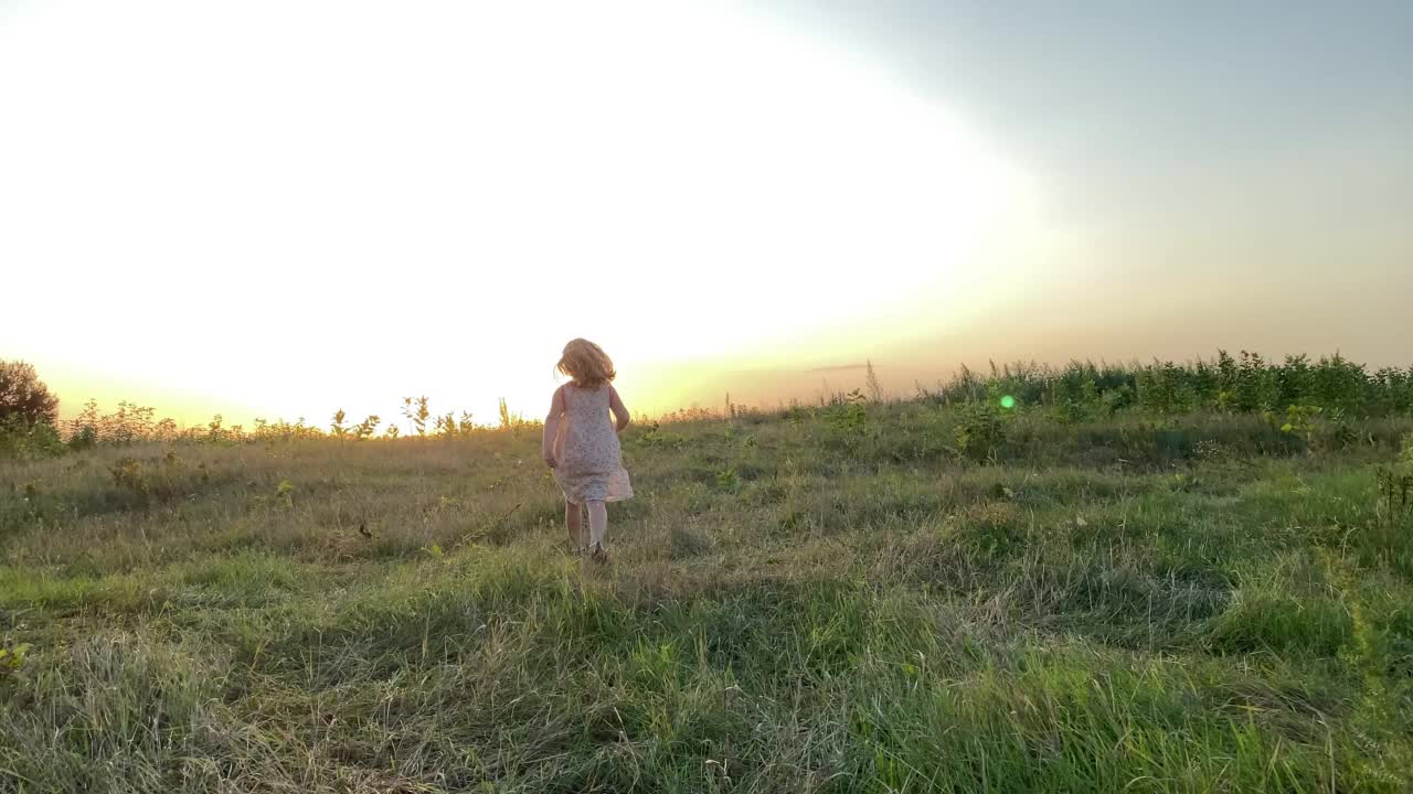 后视图快乐的女孩在户外玩日落视频素材