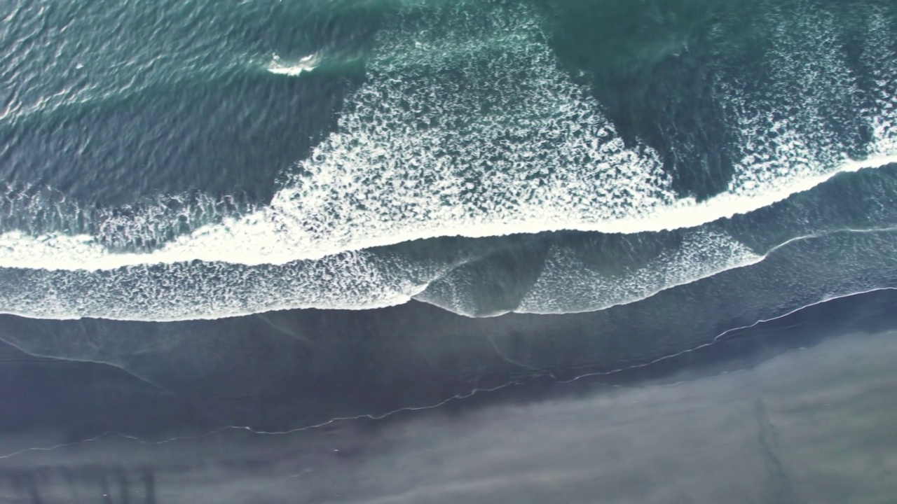 夏天海浪和黑色沙滩的鸟瞰图视频素材