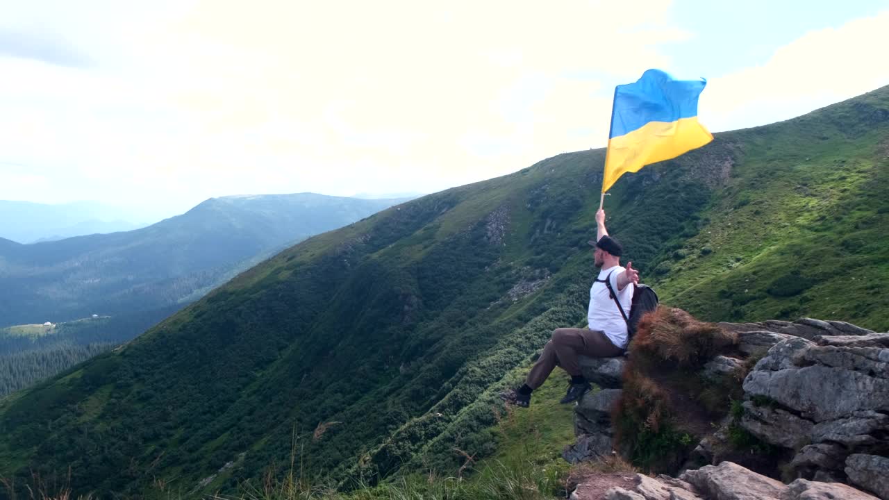 一名徒步旅行者坐在悬崖上欣赏喀尔巴阡山脉的风景视频素材