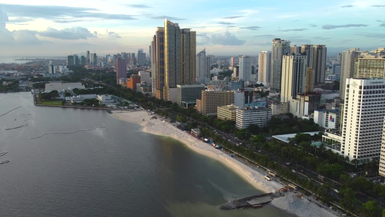 无人机POV在海滩上空飞向马尼拉的城市景观视频素材