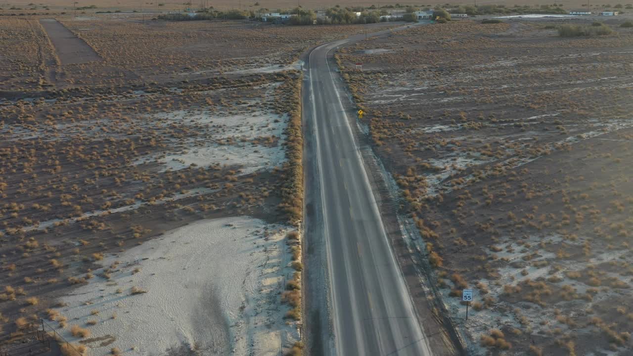 鸟瞰图，加利福尼亚沙漠中一条孤零零的道路上有房子视频素材