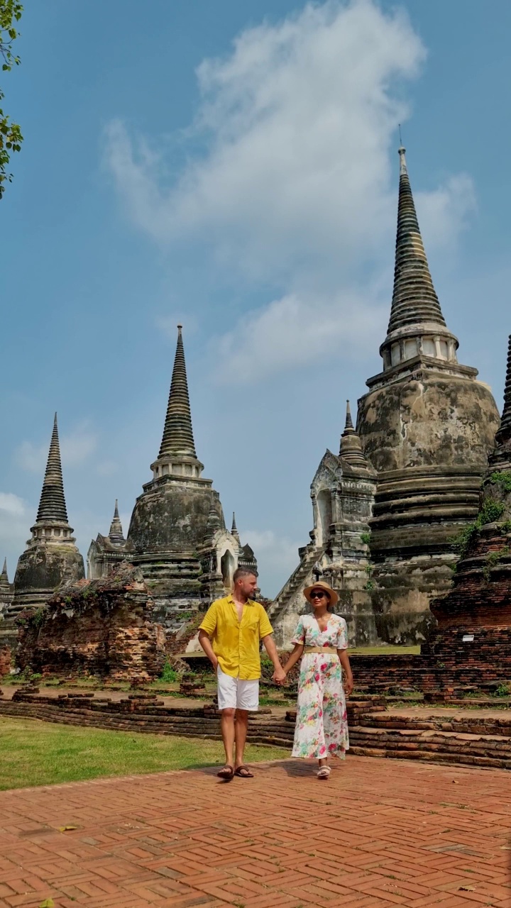 泰国，大城府，在Wat Phra Si Sanphet，一对戴着帽子的男女正在参观泰国大城府视频素材