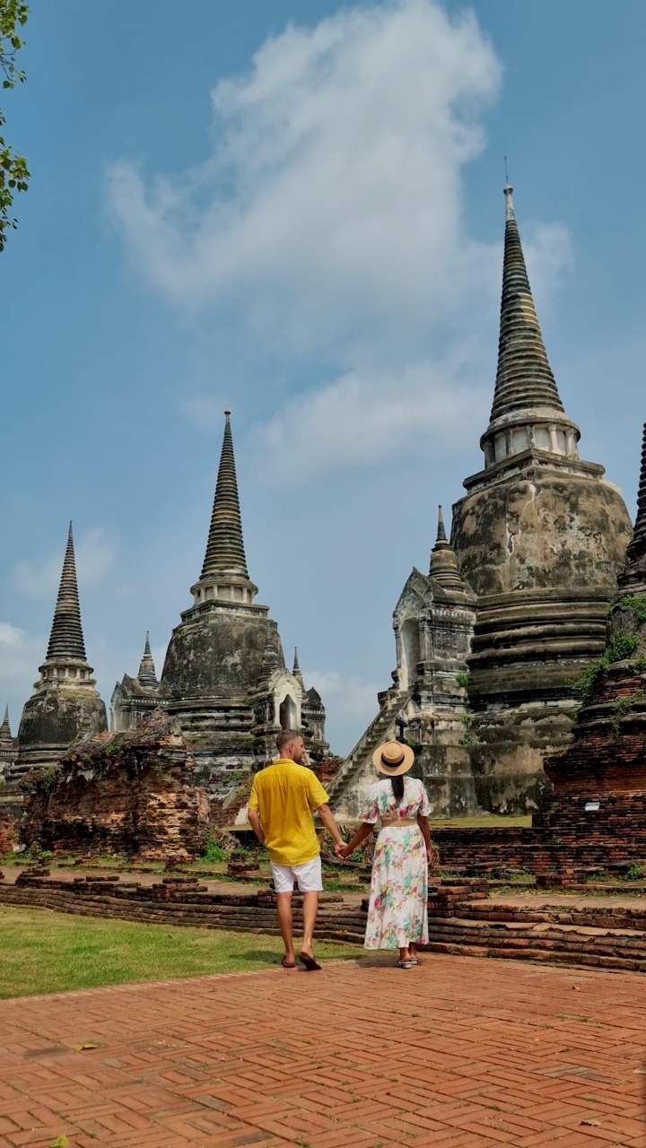 泰国，大城府，在Wat Phra Si Sanphet，一对戴着帽子的男女正在参观泰国大城府视频素材