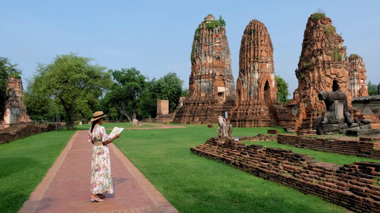 泰国大城府，在大摩诃寺，戴着帽子的妇女和旅游地图参观泰国大城府视频素材