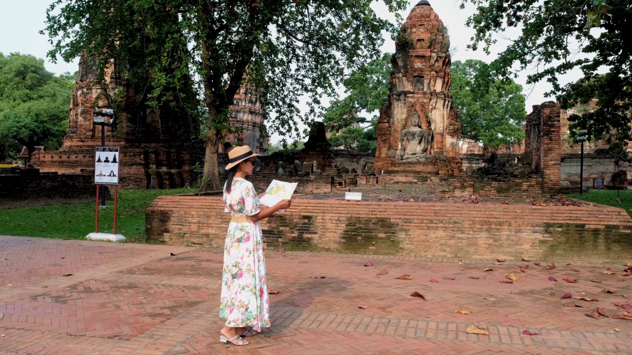 泰国大城府，在大摩诃寺，戴着帽子的妇女和旅游地图参观泰国大城府视频素材