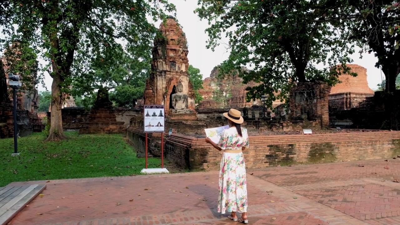 泰国大城府，在大摩诃寺，戴着帽子的妇女和旅游地图参观泰国大城府视频素材