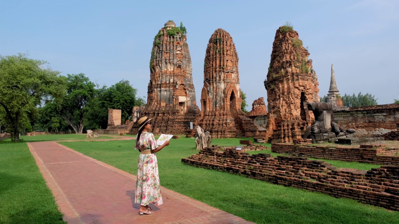 泰国大城府，在大摩诃寺，戴着帽子的妇女和旅游地图参观泰国大城府视频素材