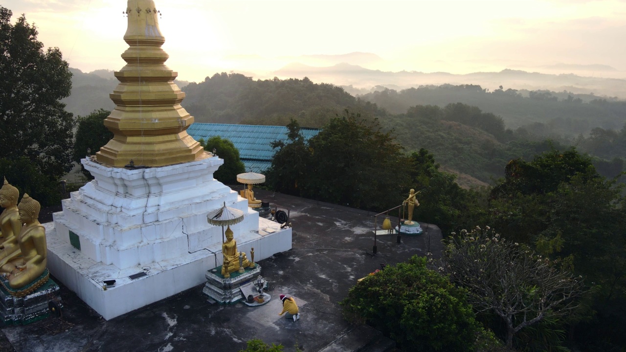 年轻的亚洲旅行家妇女祈祷尊重佛建筑佛塔在Phrae，泰国。视频素材