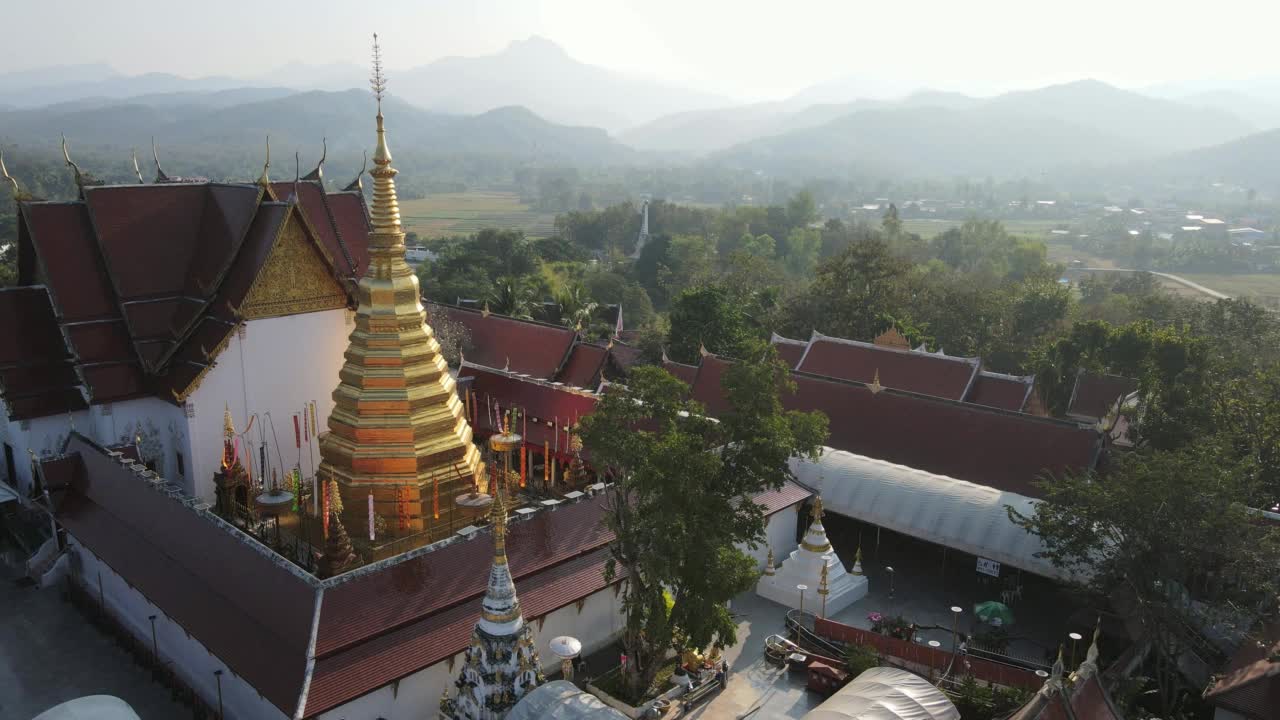 图为无人机拍摄的泰国普雷省佛寺美丽的金塔。丛林中古老的寺庙，旅游目的地视频素材