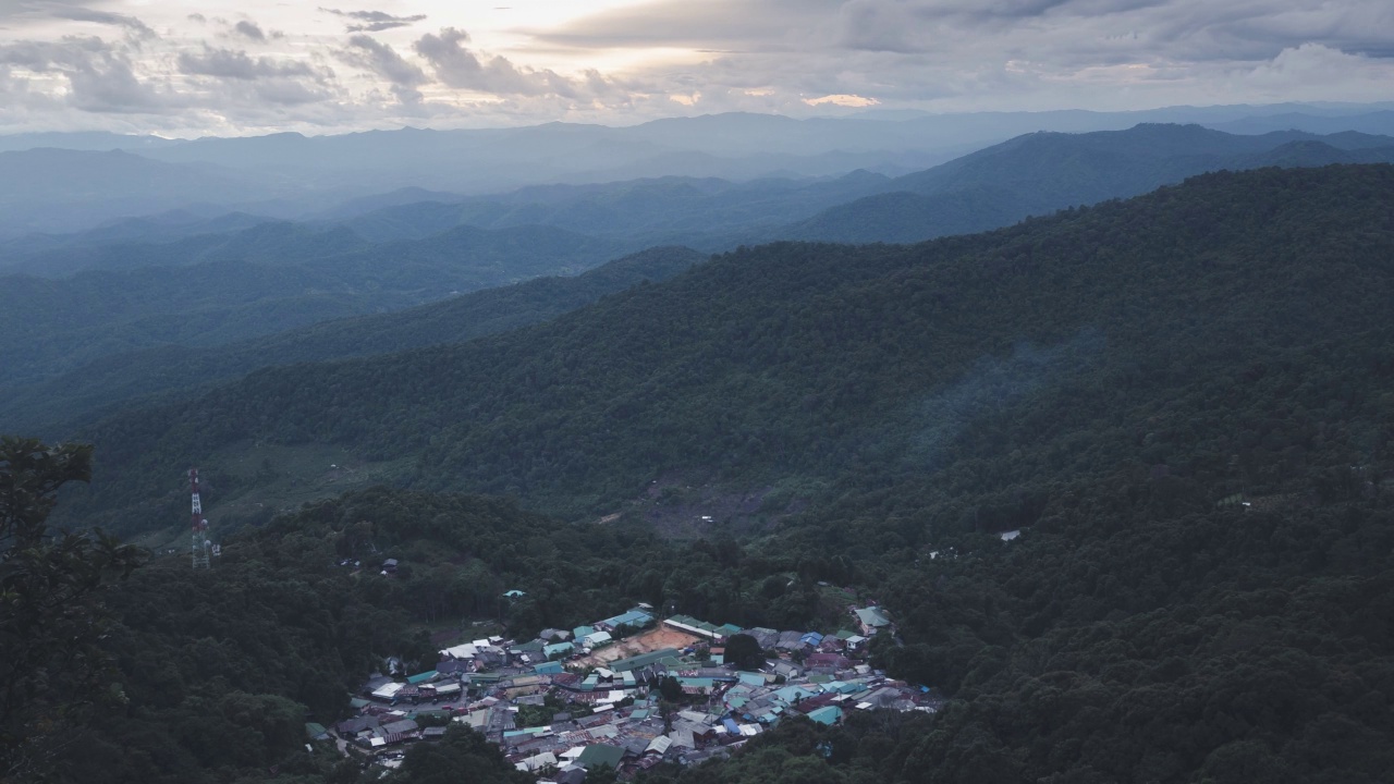 雾和烟在山谷中的一个小村庄上空缓缓飘荡。视频素材