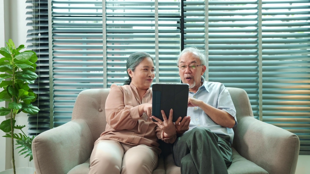 退休的亚洲老夫妇使用平板电脑视频通话问候儿子或女儿的肖像视频素材