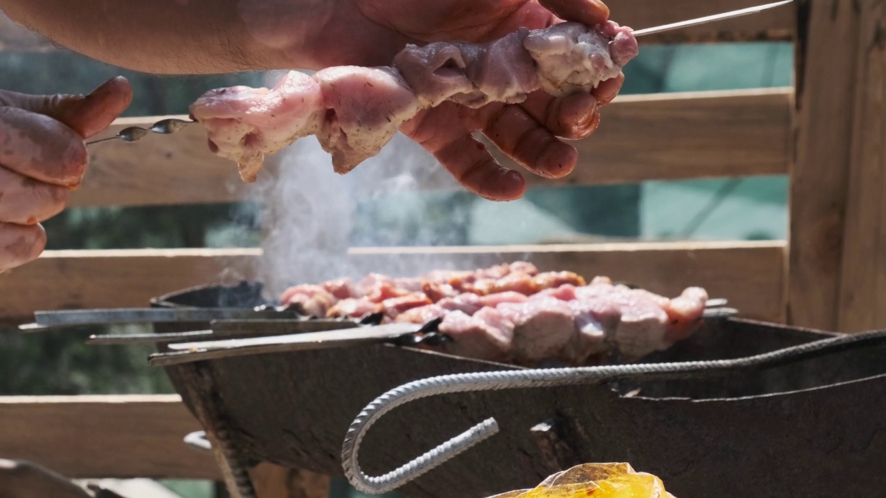 夏日户外用金属串烹制美味羊肉串的过程视频素材