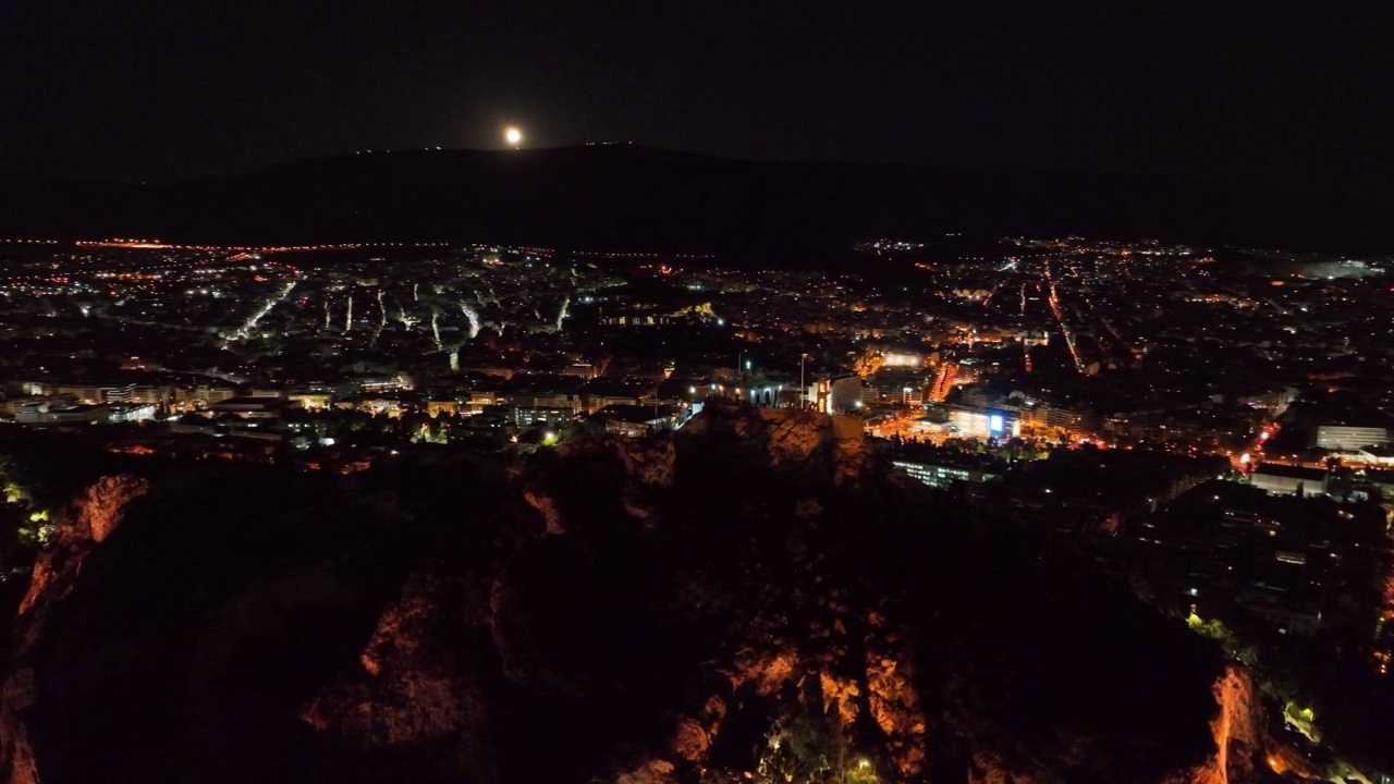 在满月的夜晚，在希腊雅典利卡贝托斯山上的小教堂上空飞行视频素材