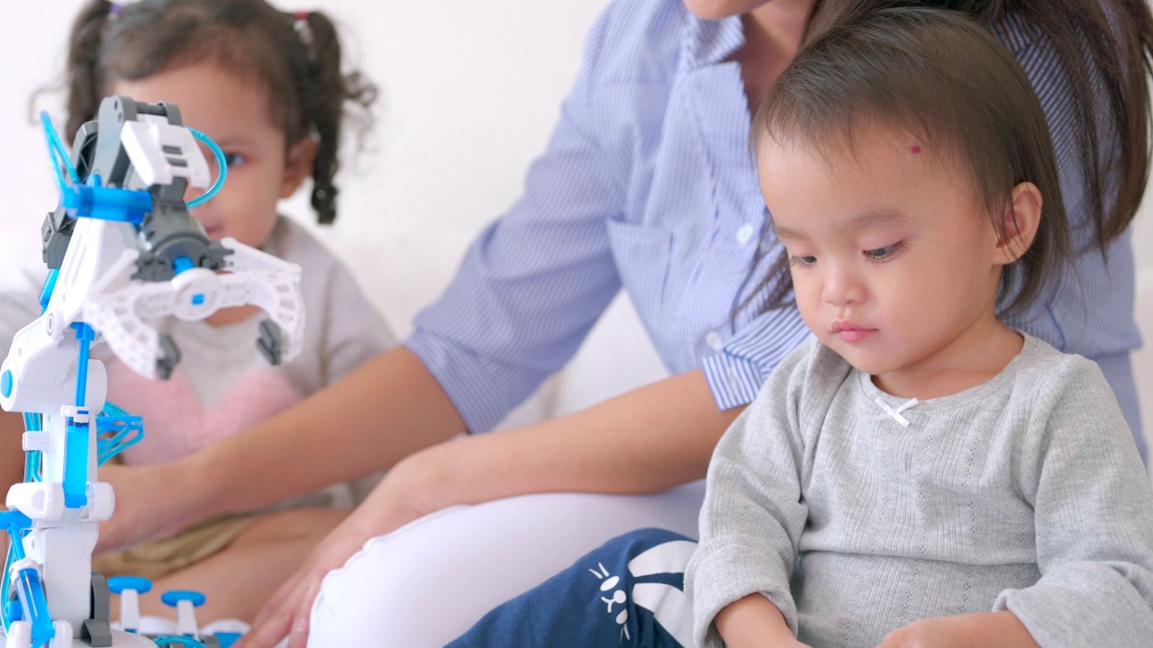 两个小孩和他们的妈妈在床上玩玩具。视频素材