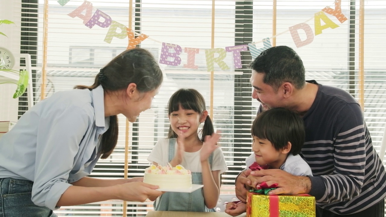 年幼的孩子们会为生日派对感到惊喜，并和家人一起庆祝。视频素材