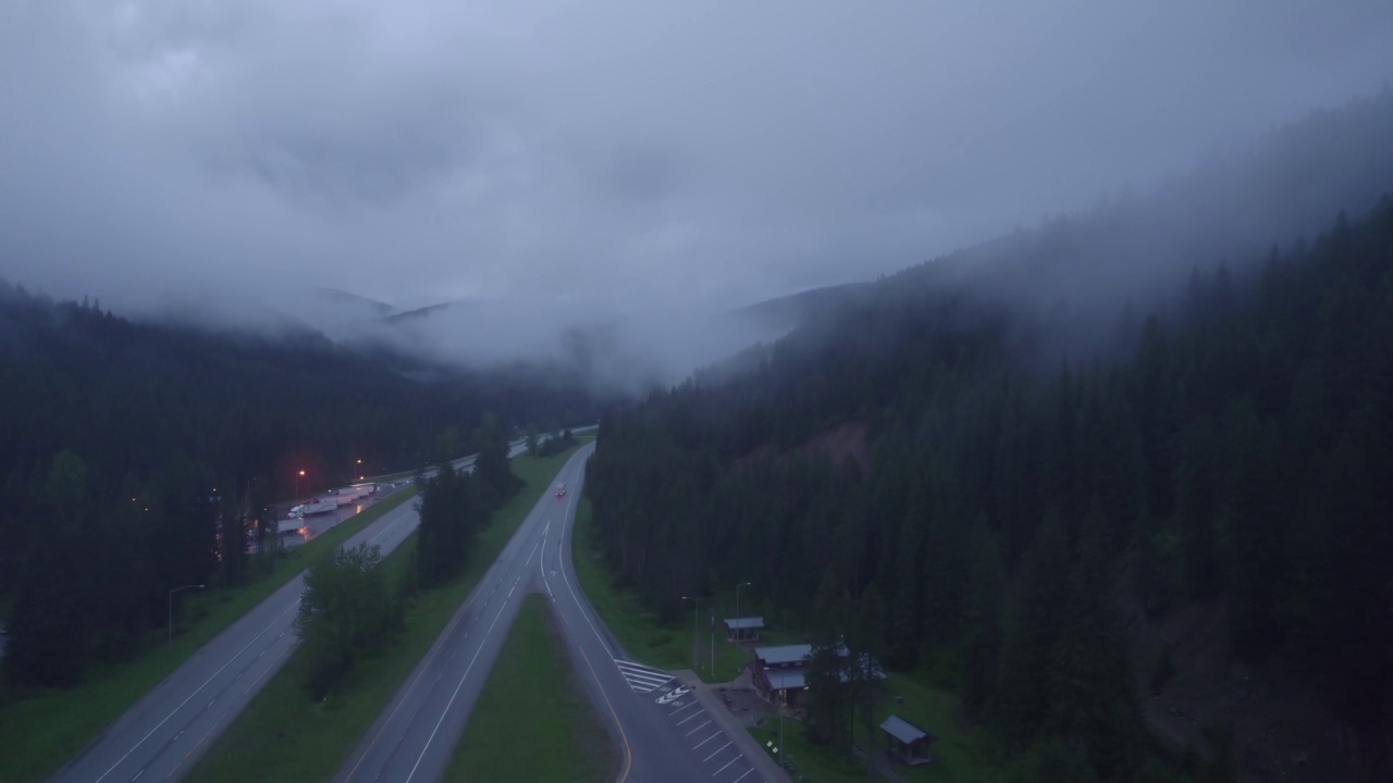 在山区的雨天，汽车和卡车在高速公路上行驶。视频素材