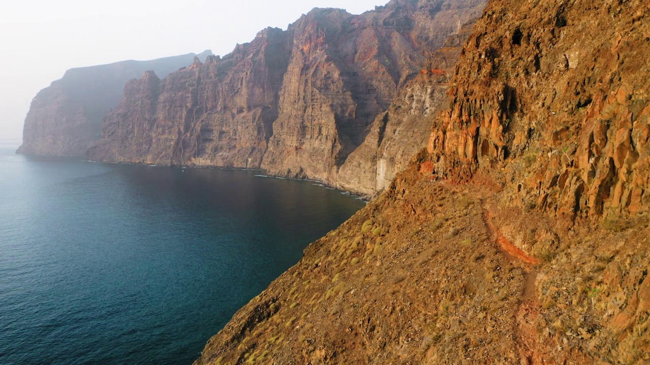 特内里费岛有崎岖不平的道路和美丽的海景。沿着洛斯·吉甘特陡峭悬崖边缘的一条危险狭窄的小路。通往地下隧道的神奇的生命威胁路线。大自然。视频素材