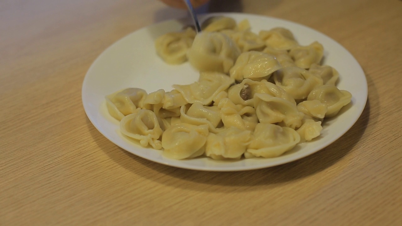 男人在家里的厨房里吃着牛肉饺子视频素材