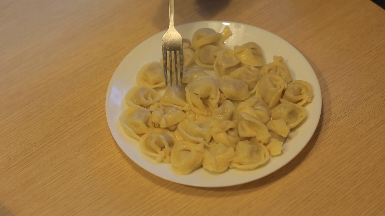 男人在家里的厨房里吃着牛肉饺子视频素材