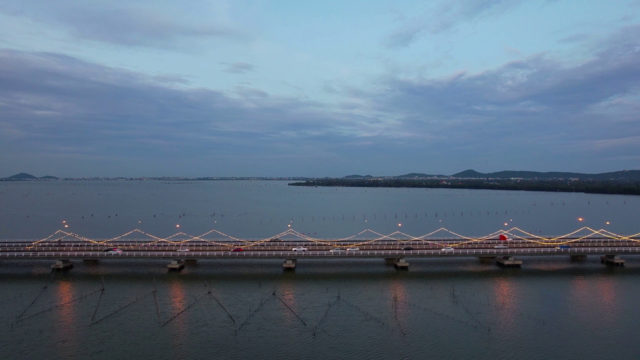 夜间的运输方式。从空中拍摄的汽车行驶在泰国宋卡省渡海大桥上视频素材