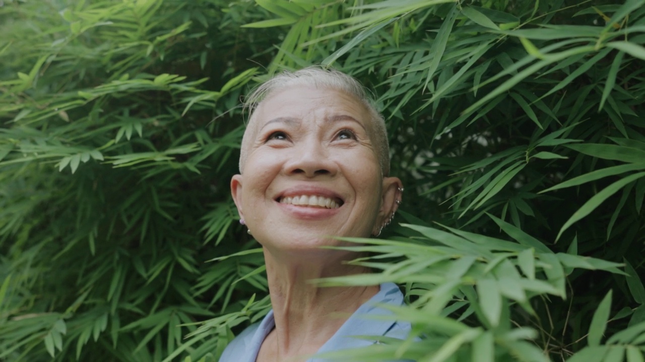 时髦的高级妇女高兴地在户外树区旅行视频素材