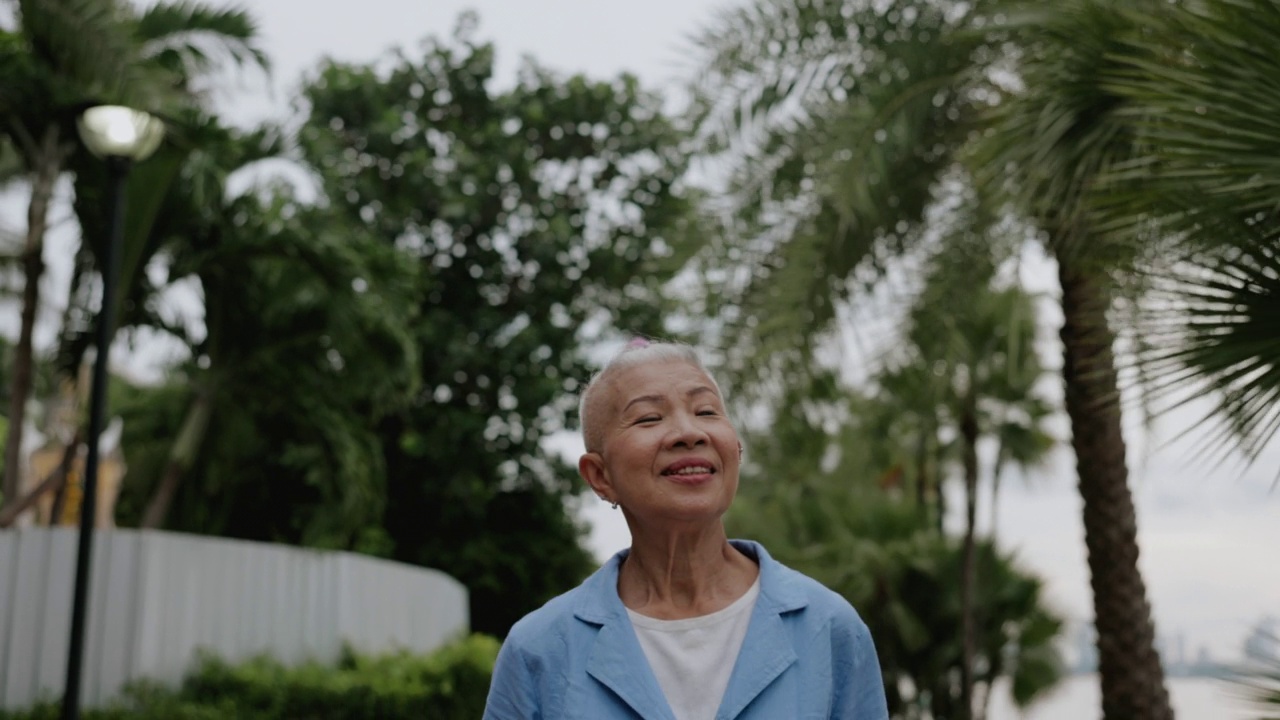 时髦的高级妇女高兴地在户外树区旅行视频素材