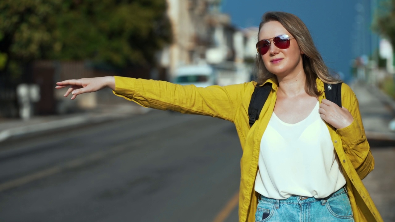 背着背包的女人在路上抓车。通过自动停止旅行。视频素材