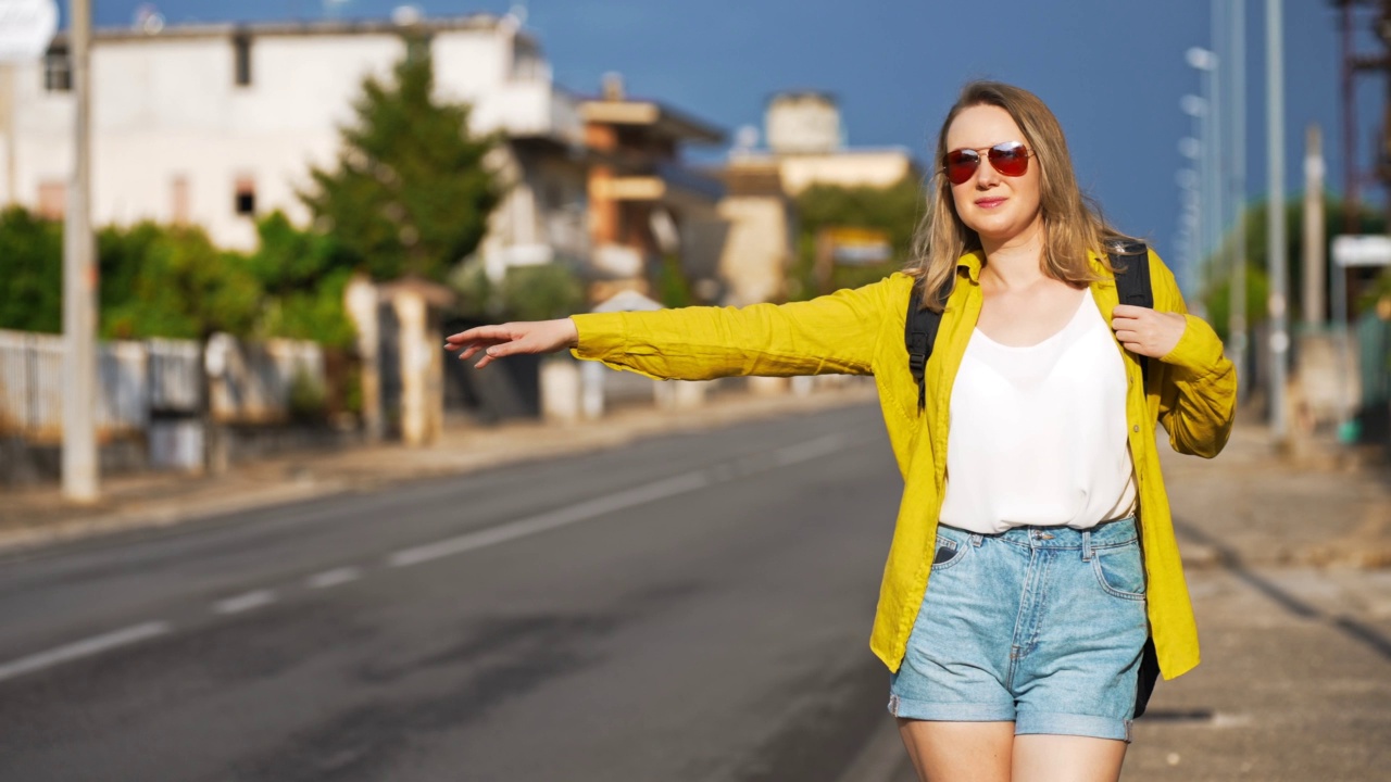 背着背包的女人在路上抓车。通过自动停止旅行。视频素材