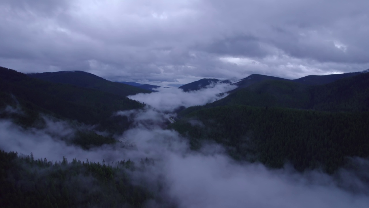 在山区的雨天，汽车和卡车在高速公路上行驶。视频素材