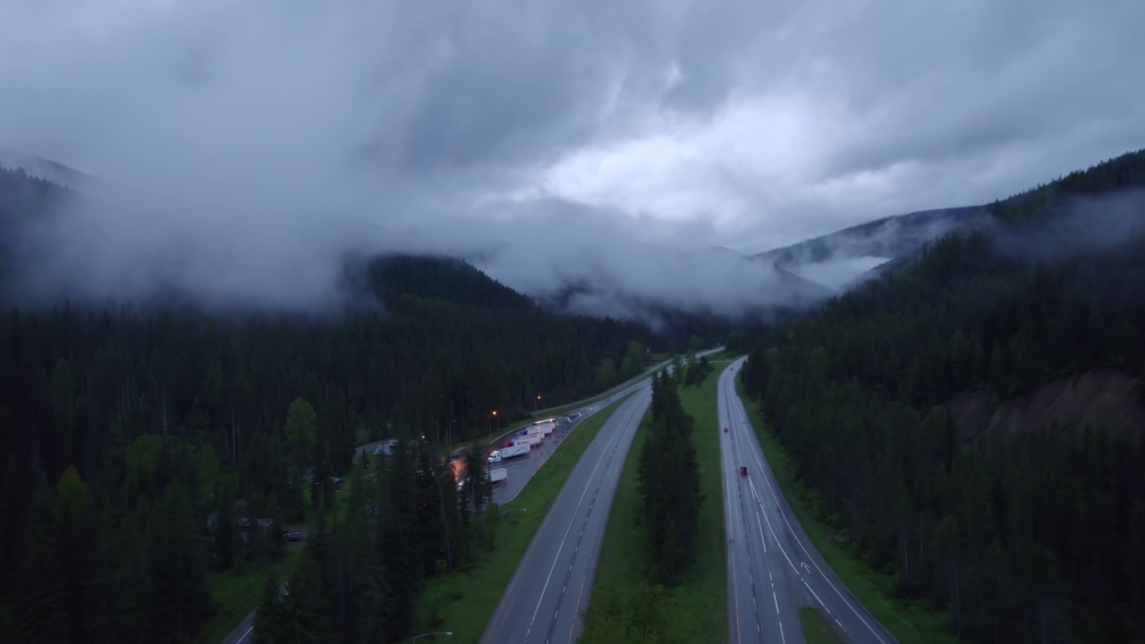 在山区的雨天，汽车和卡车在高速公路上行驶。视频素材