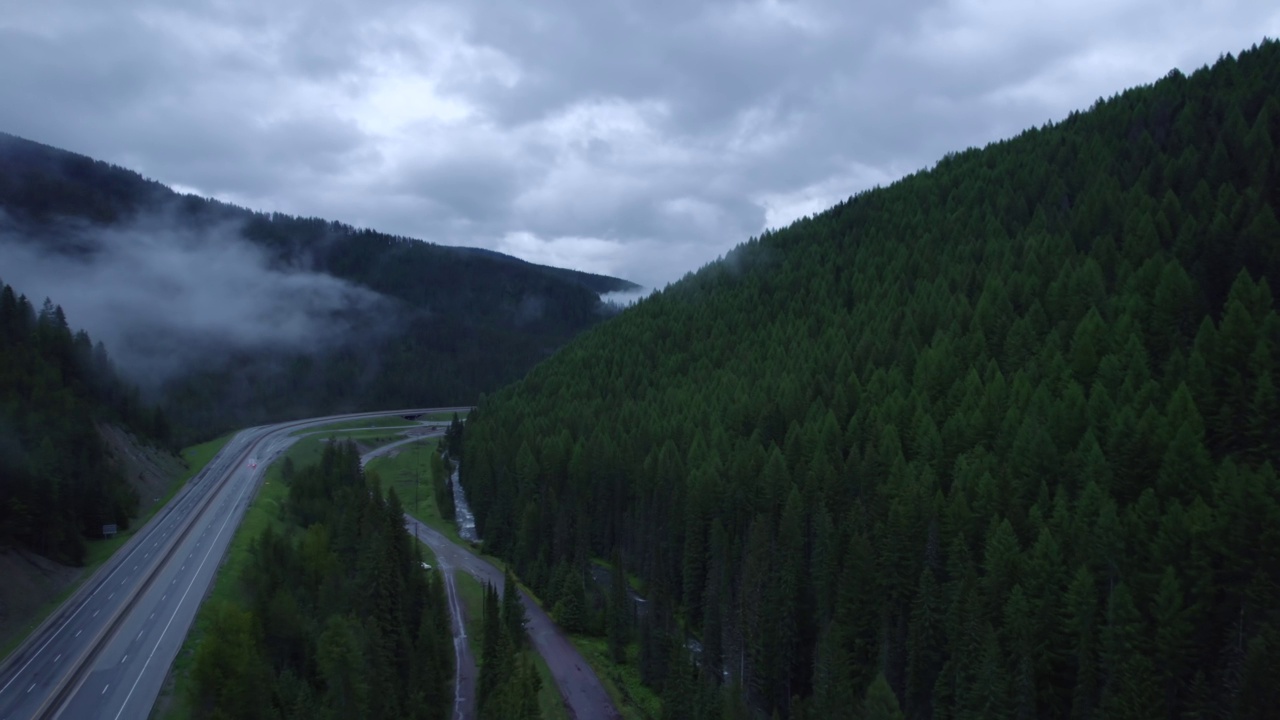 在山区的雨天，汽车和卡车在高速公路上行驶。视频素材