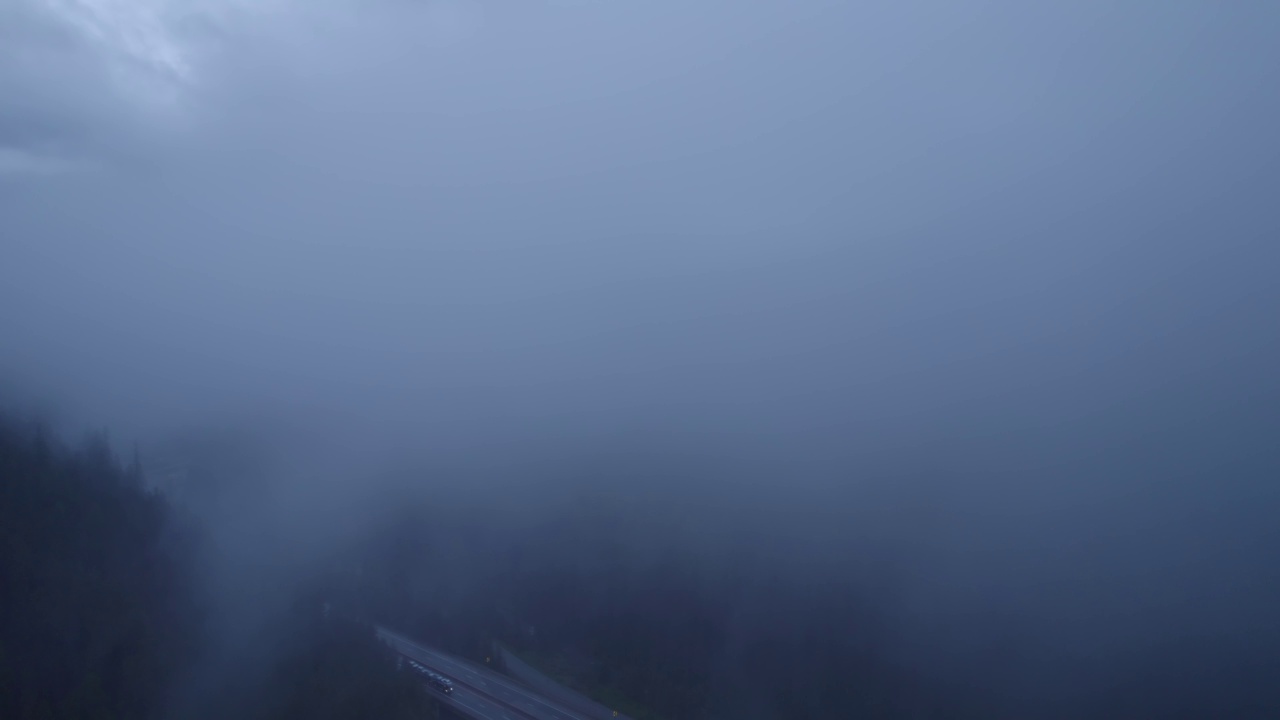 在山区的雨天，汽车和卡车在高速公路上行驶。视频素材