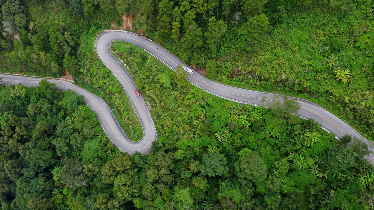 泰国山顶公路的鸟瞰图，上面有美丽的绿色森林。动态的自然景观背景。旅游和交通概念视频素材