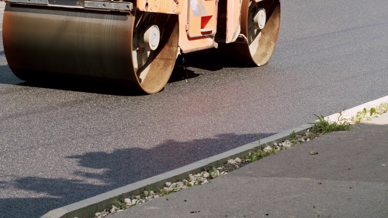 道路建筑沥青摊铺机是铺设一层新的沥青，沥青路视频素材