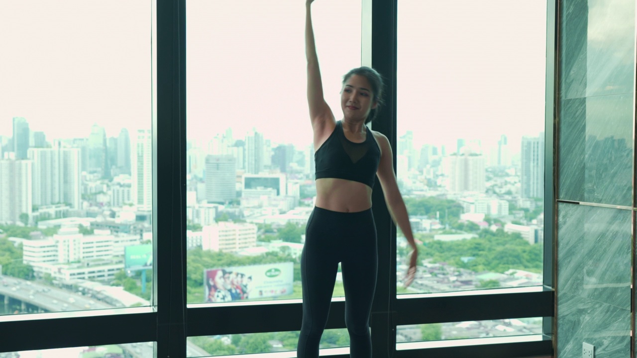 亚洲年轻成年妇女在运动服装做全身伸展后，体重锻炼在豪华健身俱乐部。视频素材