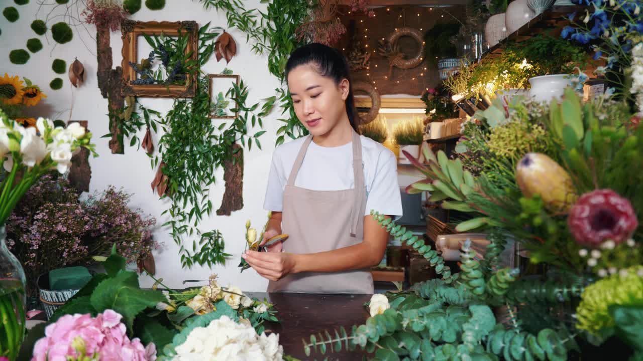 一位在花店工作的女花匠的肖像。视频素材